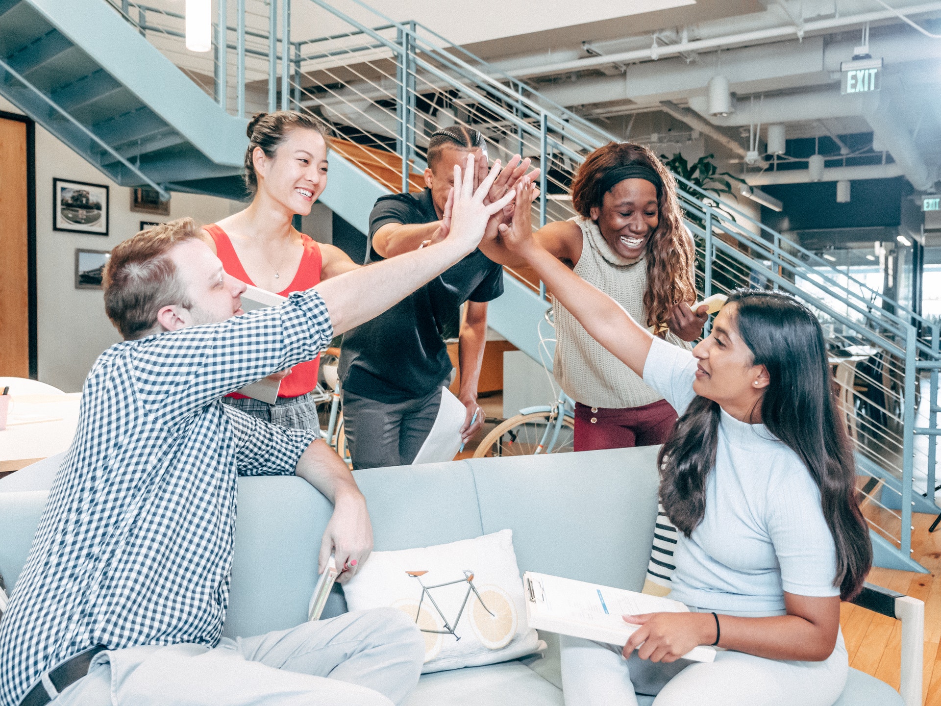 Diverse group of men and women high-fiving about organizational success