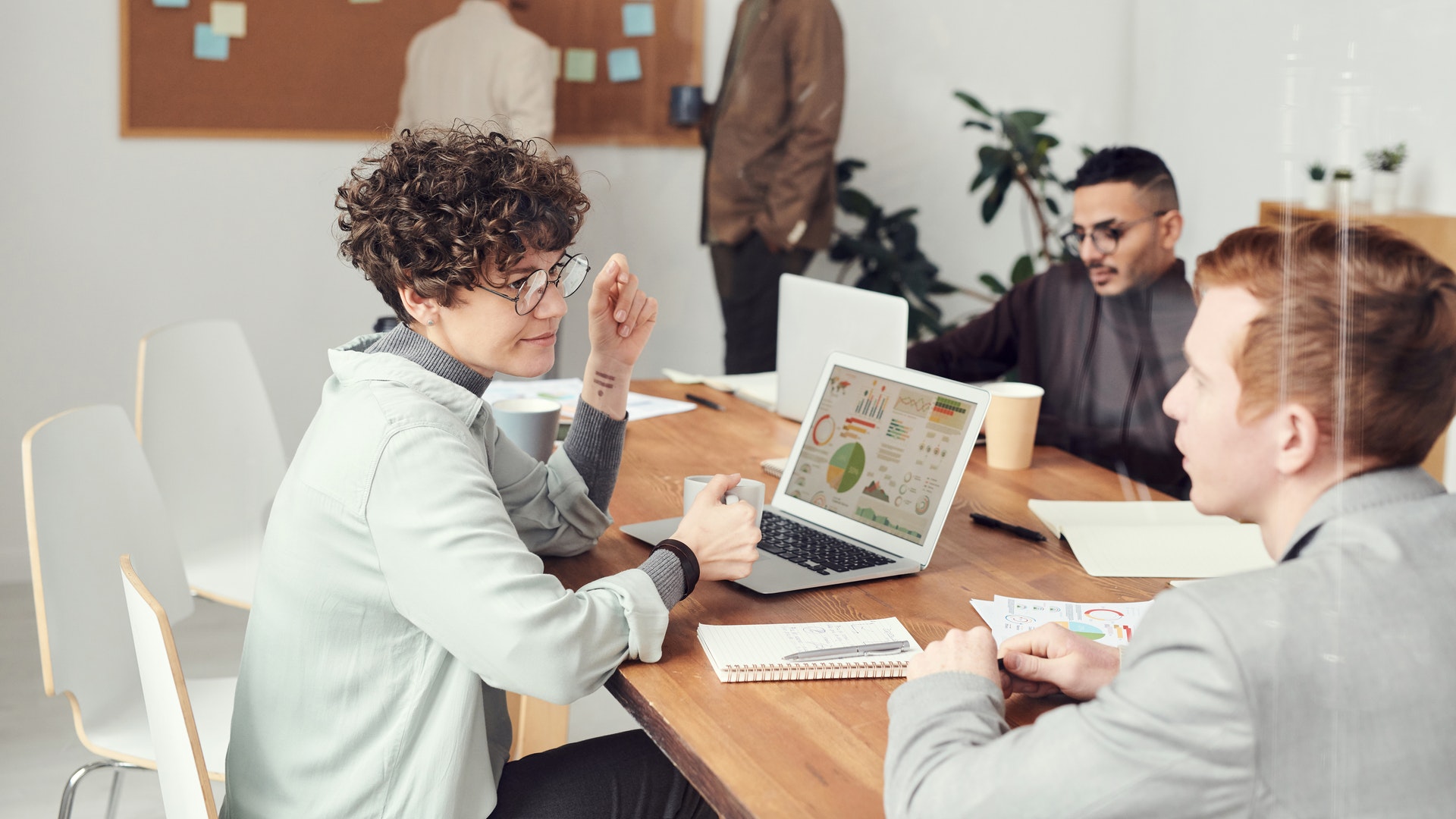 Woman sitting at desk in meeting with direct reports