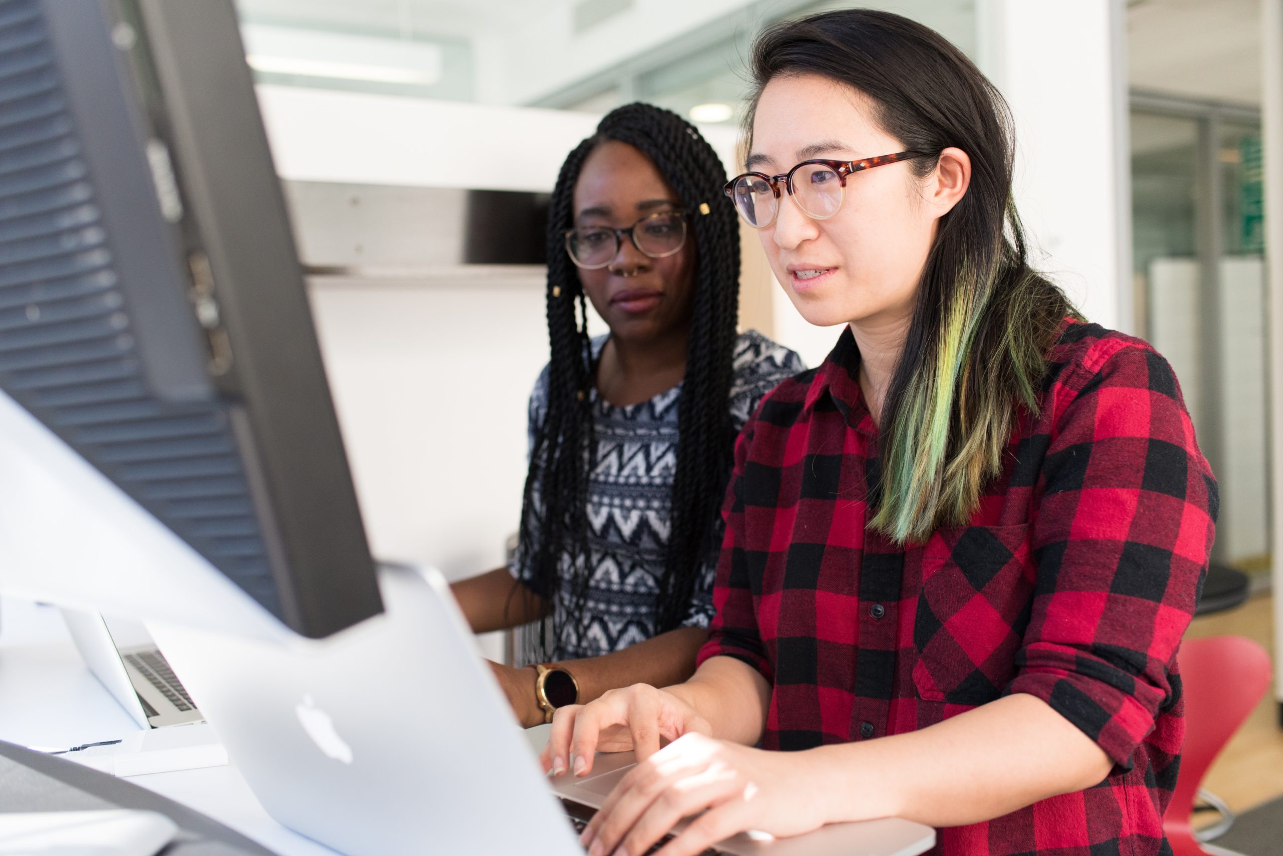 Asian woman and Black woman reviewing employee engagement action plan