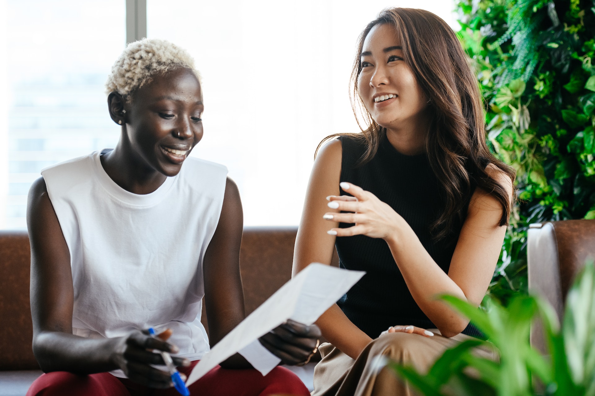 Two women colleagues happily doing an employee assessment