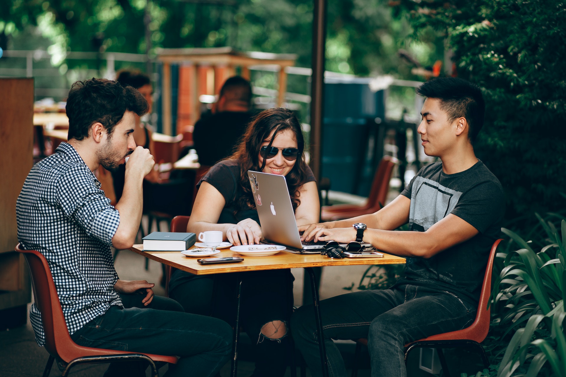 Three colleagues in casual dress outside working on goal setting activities