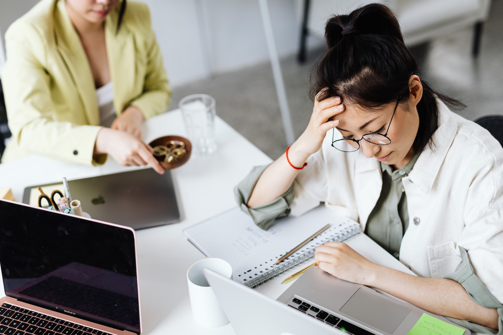 Overworked employees at desk with laptops