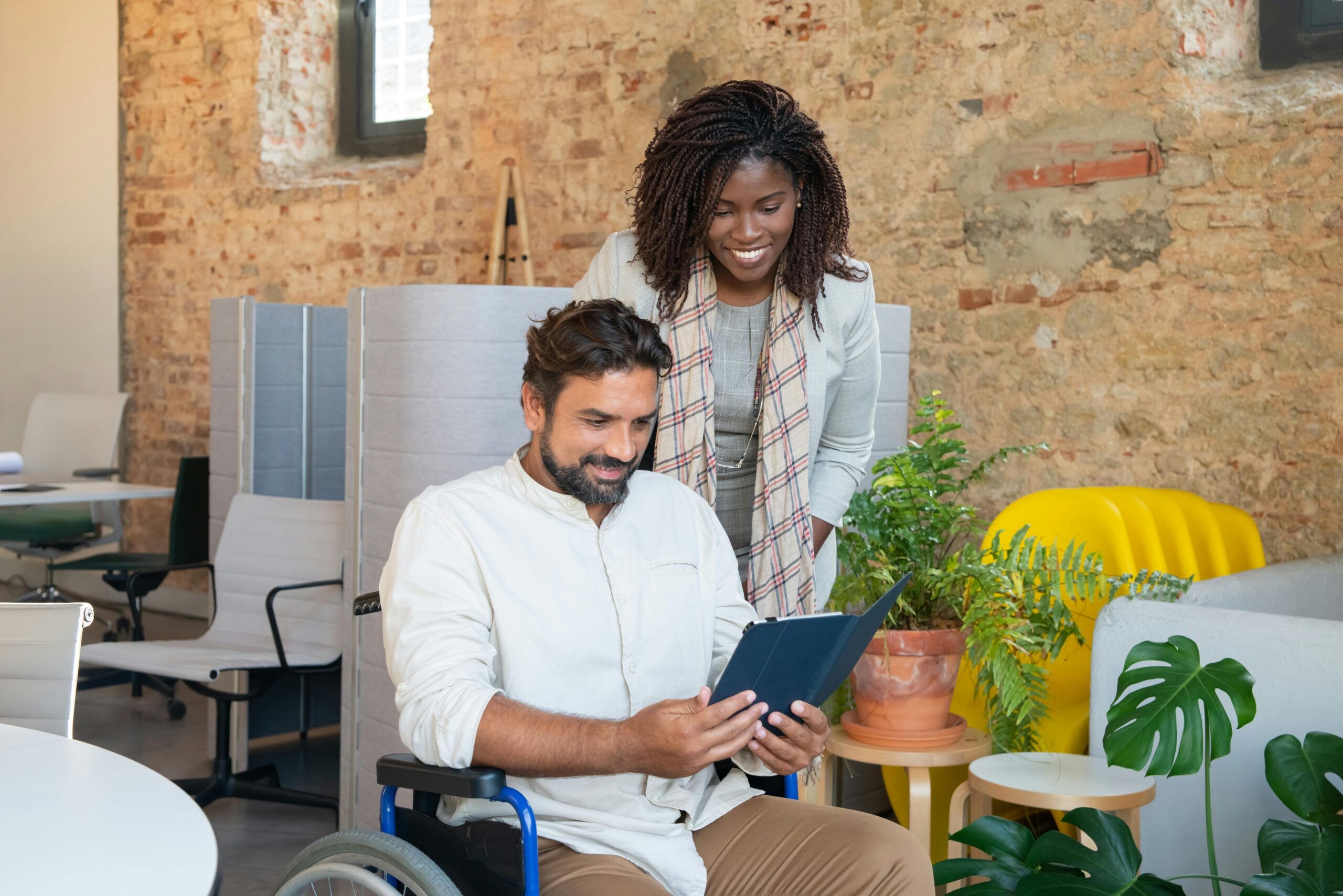 A woman and a man in a wheelchair discussing HR tactics to implement in 2024