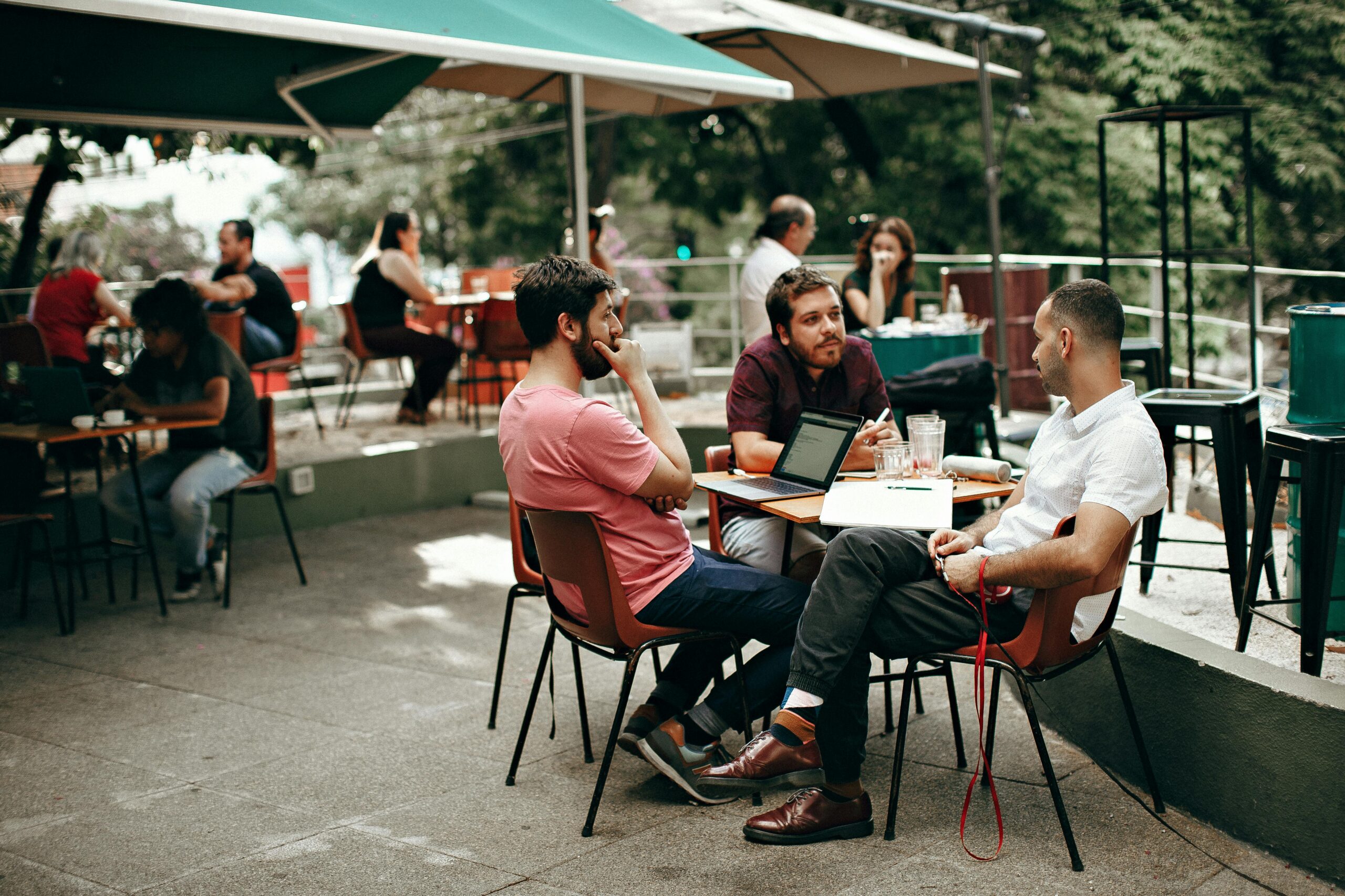 Three coworkers bonding during an outdoor meeting 